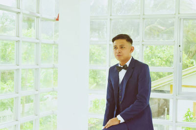 Young man standing in window