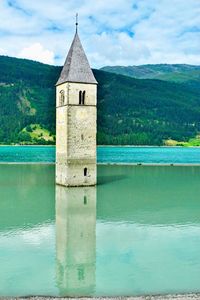 Built structure by lake against sky