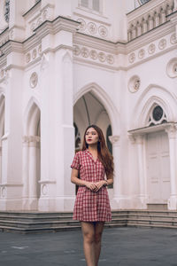 Woman standing against building