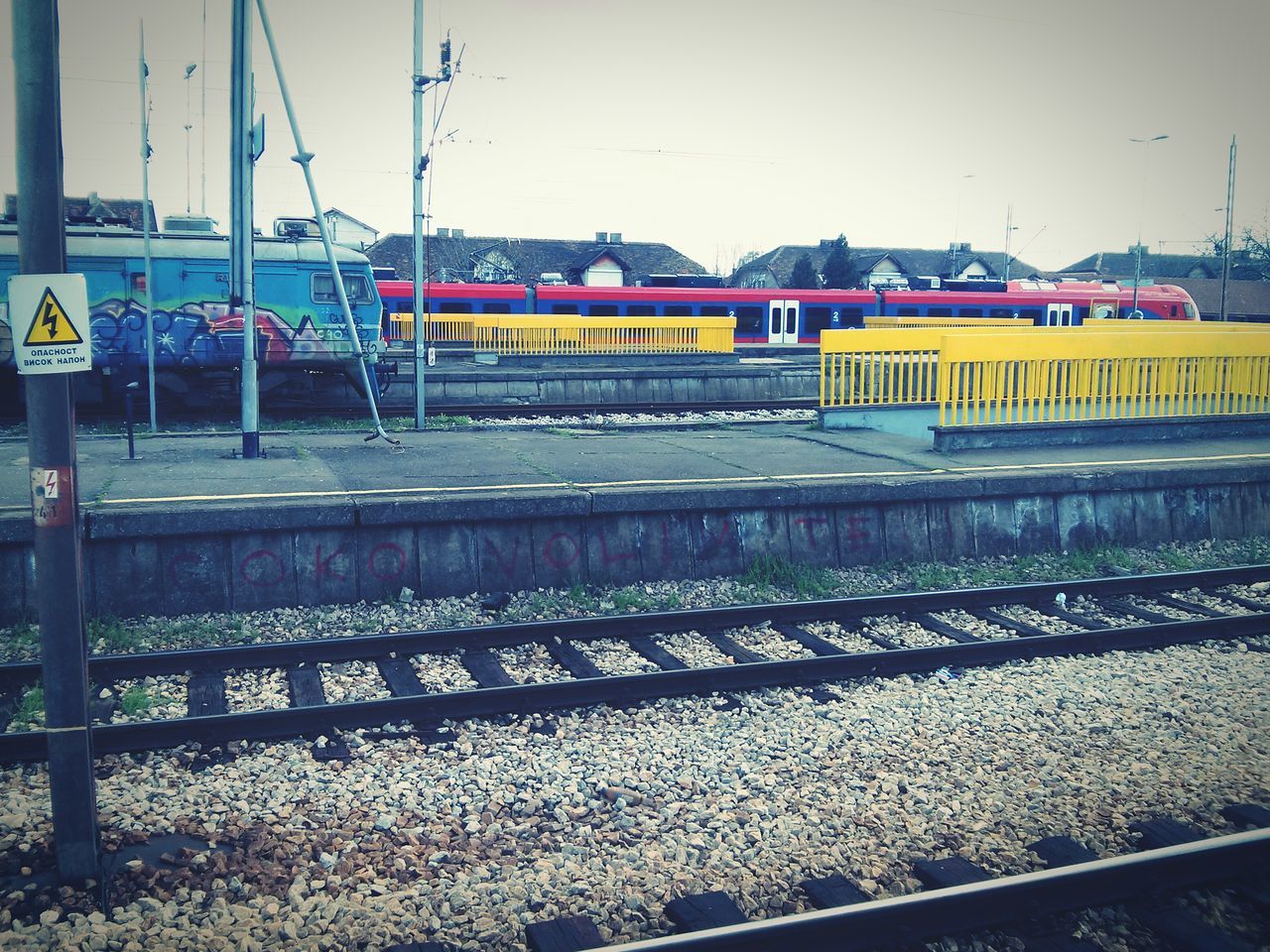 railroad track, transportation, rail transportation, public transportation, clear sky, train - vehicle, railroad station platform, railroad station, mode of transport, train, passenger train, built structure, architecture, travel, railway track, sky, outdoors, public transport, day, land vehicle