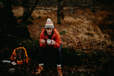 Woman drinking coffee in forest