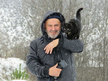 Portrait of smiling young woman standing in snow
