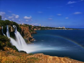 Scenic view of waterfall against sky