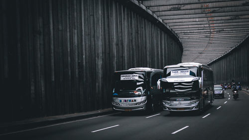 Cars on road against wall in city