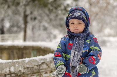 Cute baby boy standing outdoors