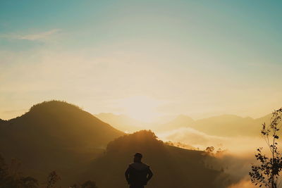 Rear view of silhouette man against sky during sunset