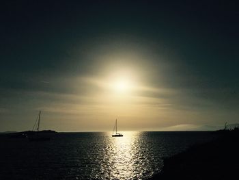 Sailboat sailing in sea at sunset