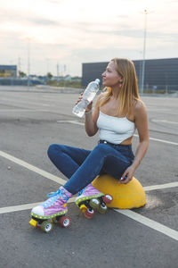 Young woman sitting on road in city