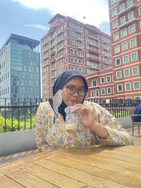 Low angle view of young woman standing against building