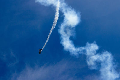 Low angle view of airplane flying against blue sky