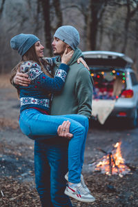 Rear view of couple kissing in park during winter