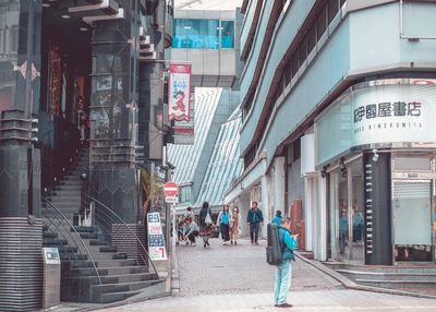 People walking on street amidst buildings in city