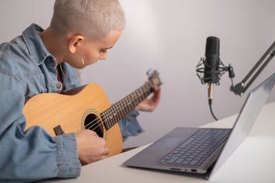 Full length of boy playing guitar