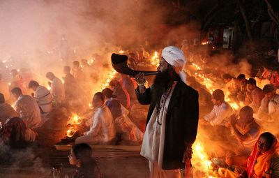 A man blowing buffalo horn in rakher upobash at barodi lokhnath brahmachari ashram