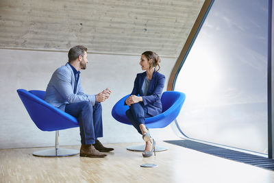 Man and woman sitting on chairs talking