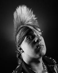 Portrait of man with spiky hair against black background