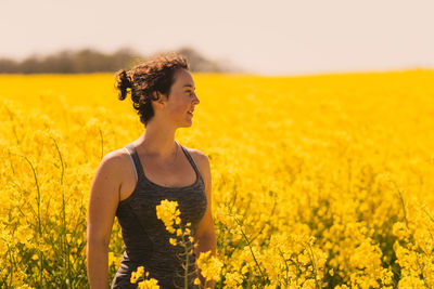 Young woman with yellow flowers in field