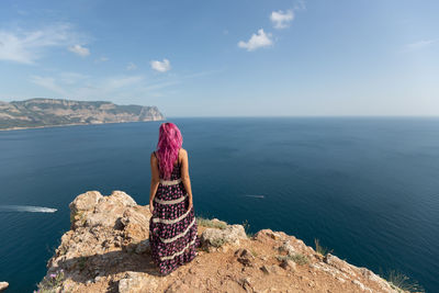 Rear view of woman looking at sea against sky