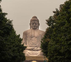 Statue of temple against trees against sky