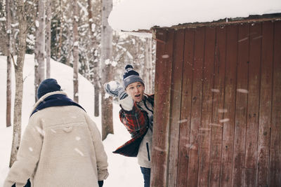Portrait of friends standing on snow during winter