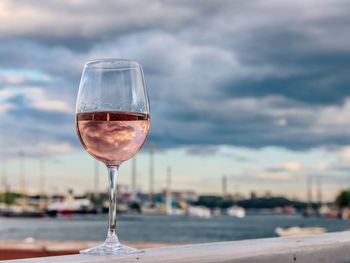 Close-up of wine glass on table against sky