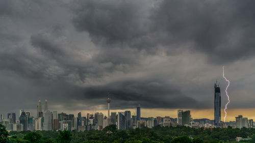 Panoramic view of buildings in city against storm clouds