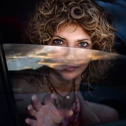 Portrait of woman with curly hair sitting in car
