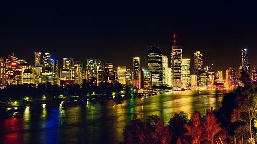 Illuminated cityscape against sky at night