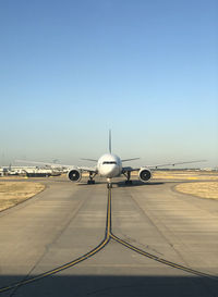 Airplane on runway against clear sky