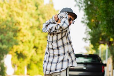 Midsection of man standing against tree