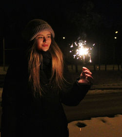 Smiling woman looking at sparkler