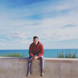 Portrait of man sitting against sea