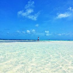 Scenic view of beach against blue sky