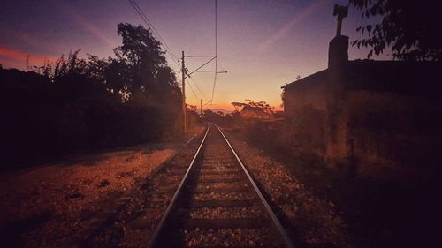 Railroad tracks against sky during sunset