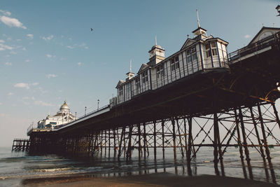 Eastbourne pier at beach against sky