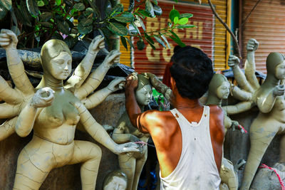 Rear view of man statue outside temple