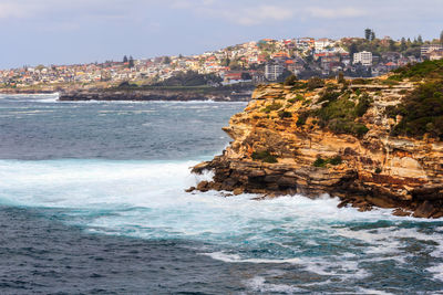 Scenic view of sea by buildings against sky