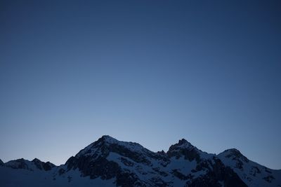 Scenic view of snowcapped mountains against clear blue sky