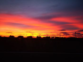 Silhouette landscape against dramatic sky during sunset