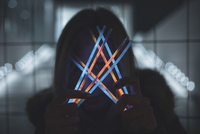 Woman holding colorful equipment at night