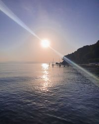 Scenic view of sea against bright sun