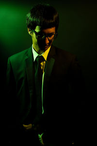 Portrait of young man against black background