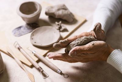 Cropped hands of man preparing food on table