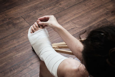 A woman massages the toes of a broken leg with her hands. 