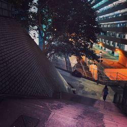 Illuminated street amidst buildings in city at night