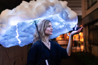 Digital composite image woman holding cloud shaped umbrella