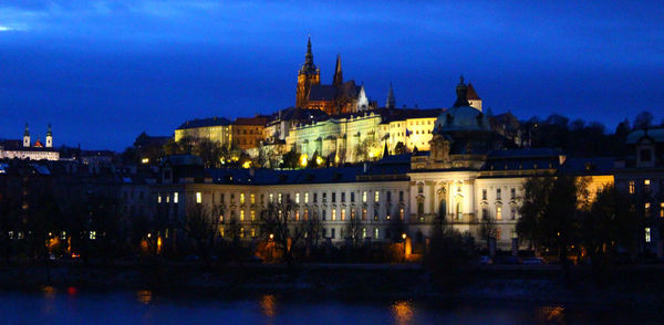 Illuminated buildings against sky at dusk