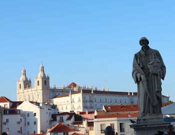 Statue of buildings against clear blue sky