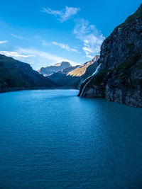 Scenic view of sea and mountains against blue sky