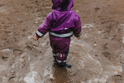 Toddler standing in puddle